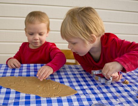 Children working together making gingerbread cookies for christmas