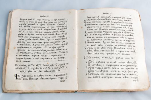 Opened old religious book with  text on Church Slavonic language isolated on white background .