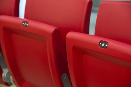 Rows of empty red seats in a football stadium