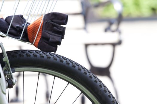 View of bicycle wheel and bicyclist glove at Princeton Train Station, Princeon, NJ, USA; Hints of independence, fitness, and travel; 