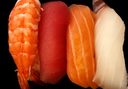 Colorful close up of sashimi/sushi against a black background highlight flavorsome, fresh textures and purity