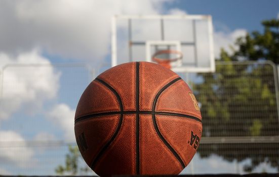 Basketball against the basketball board and the blue sky.

