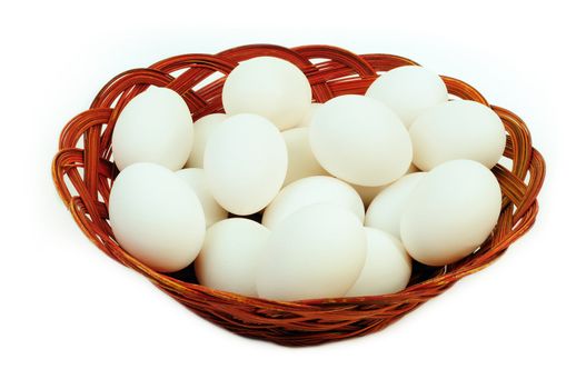 White eggs in a cane basket isolated over white background