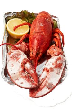 Steamed red boiled lobster with salad leaves and lemon in  restaurant .