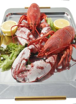 Steamed red boiled lobster with salad leaves and lemon in  restaurant .