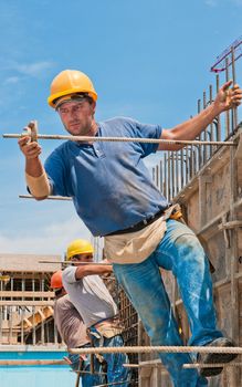 Authentic construction workers installing formwork frames prior to cement pouring