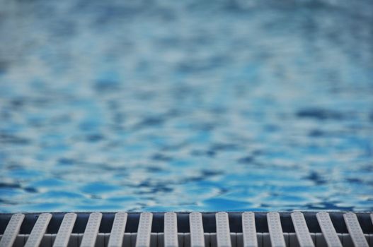 Poolside closeup on plastic frame outlining a swimming pool and water
