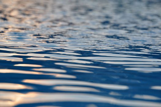 Water surface with tiny ripples and reflecting sunlight