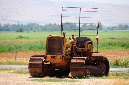 Old tractor but still operating on the field .