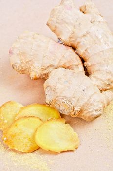 Fresh, dried and powdered ginger at brown background