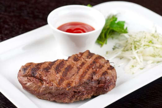 Juicy roasted beef steak with vegetables closeup at plate
