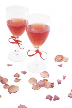 two red wine and rose petals on white background