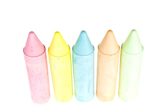 five colorful chalks on a white background