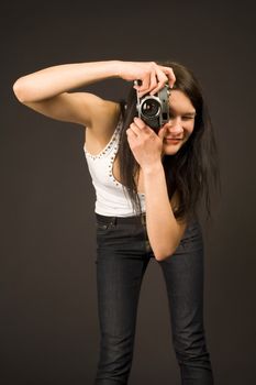 Young girl posing with camera isolated on black background
