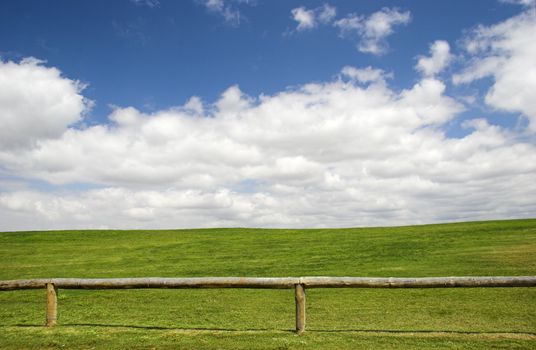 Beautiful meadow with a great blue sky and wooden fence