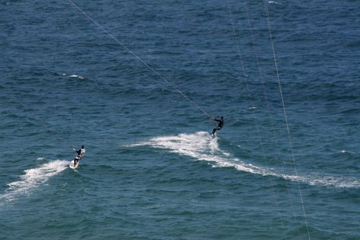 people doing kitesurf sport on holiday at a beach
