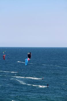 people doing kitesurf sport on holiday at a beach
