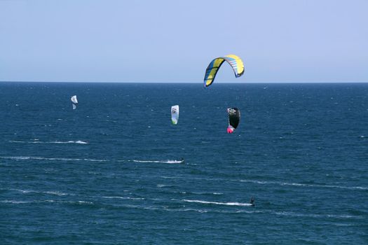 people doing kitesurf sport on holiday at a beach
