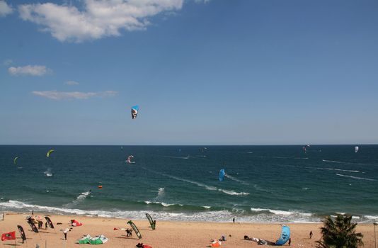 people doing kitesurf sport on holiday at a beach
