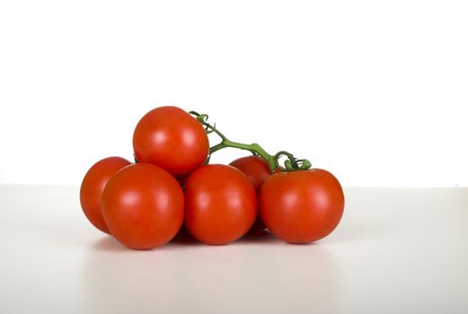 Picture of healthy tomatos over a white table