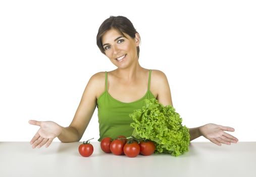 Beautiful young woman in the kitchen with healthy vegetables in front of her