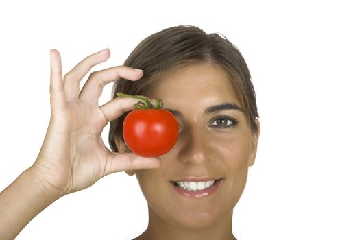 Beautiful young woman in the kitchen holding a tomato on her hand