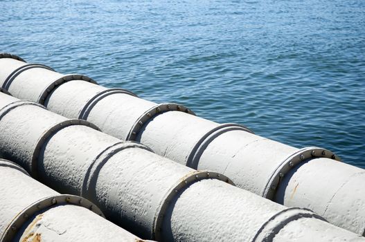 A closeup of large sewage pipes, leading out to the sea.