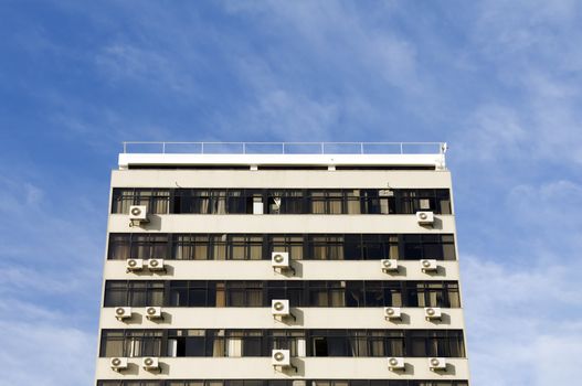 Drab, boring old building with air conditioning units in windows