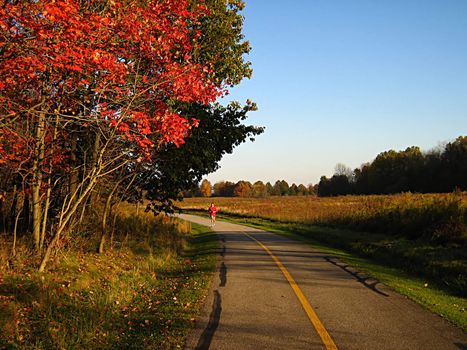 A photograph of a person running along a trail.