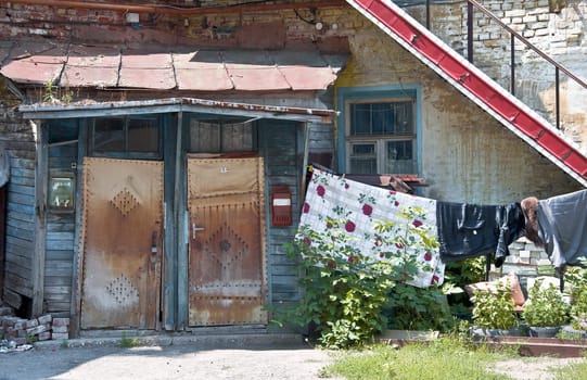 Fragment of the old court. Rickety porch and door with the mailboxes. Near the entrance to the house drying clothes. Urban fragment of the Russian provinces