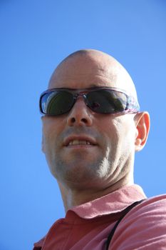 A bold caucasian man wearing sunglasses