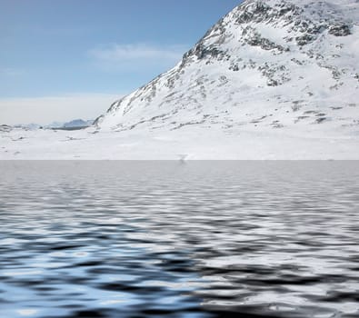 Mountains with snow reflected in lake water