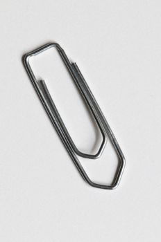 Closeup of a silver paperclip on white background
