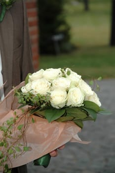 Groom is holding a wedding bouquet.