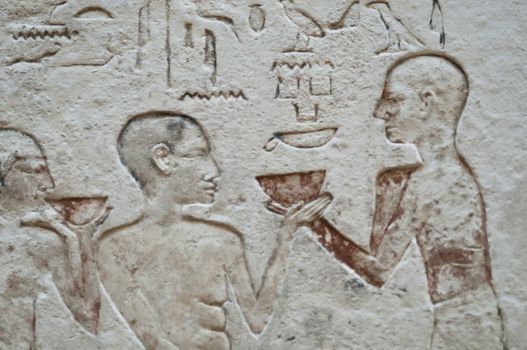 Egiptian hieroglyphs and human figures engraved on stone