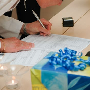 Bride signing the wedding contract. Note that all the tekst is in blur.