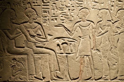 Egiptian hieroglyphs and human figures engraved on stone