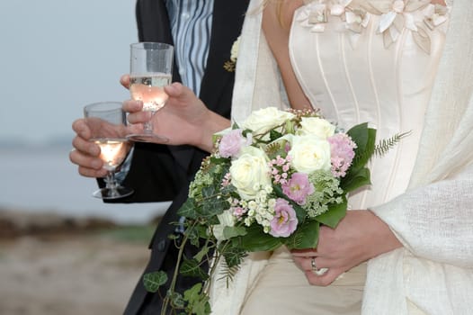 Wedding couple holding champange and flowers.