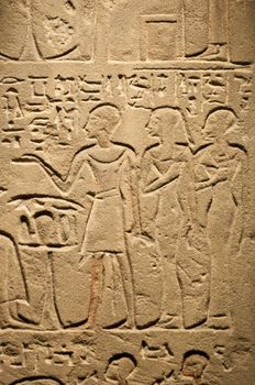 Egiptian hieroglyphs and human figures engraved on stone