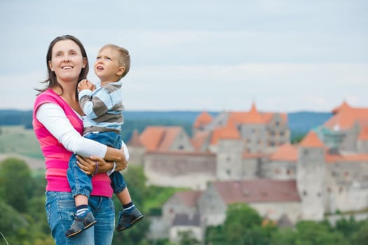 Young travelers. Young mother with her son on a tour of European medieval castles.