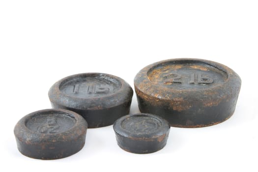 Antique imperial weights, peeling paint and rust, on white background.