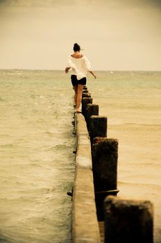 Girl walking on a wave-breaker