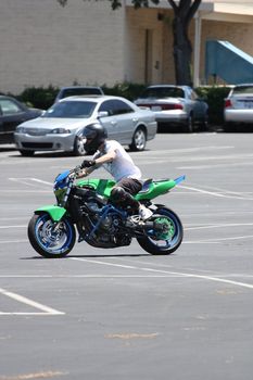 Close up of a motorcyclist on a green motorcycle.