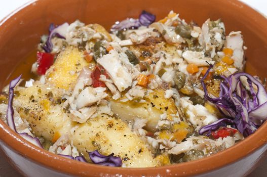 A earthenware dish with gratinated pike fish and vegetables