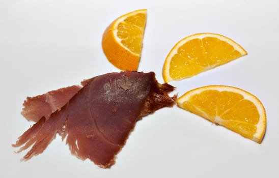 Slice of smoked tuna fish with orange slices