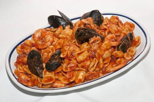 A dish of italian auricles with a seafood tomatoe sauce