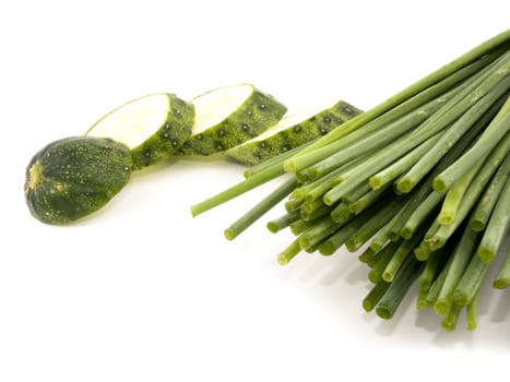 Fresh chives and sliced cucumber on white background