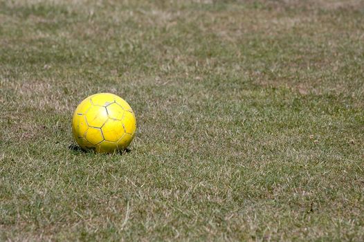 Yellow football on green grass.