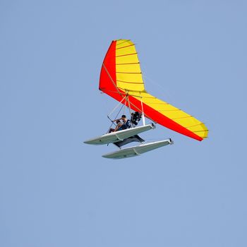 Man and woman is flying a hangglider.