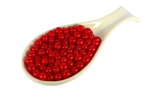 Spoon full of red currants isolated on white
